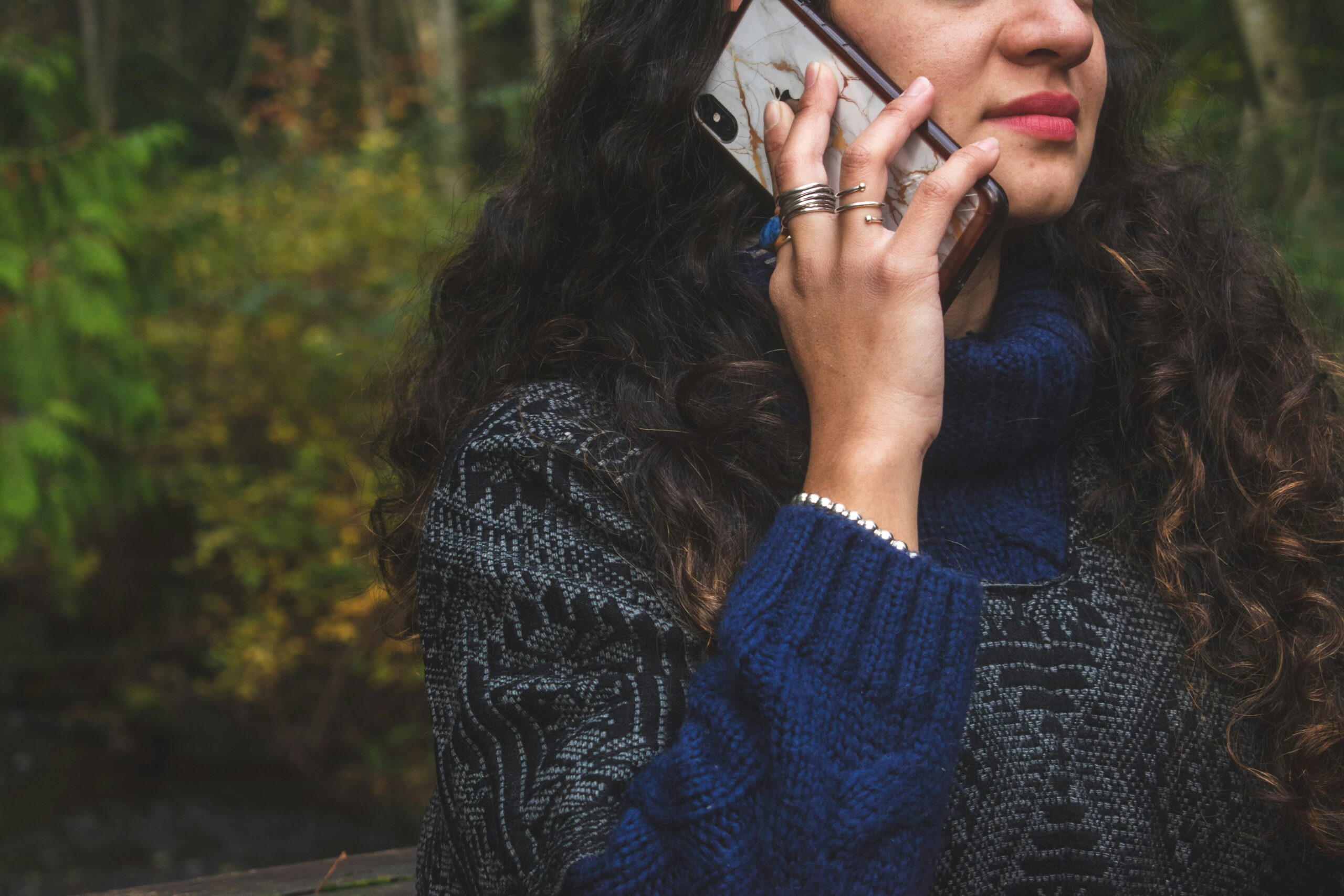 A person looking stressed while holding a phone with international emergency numbers displayed
