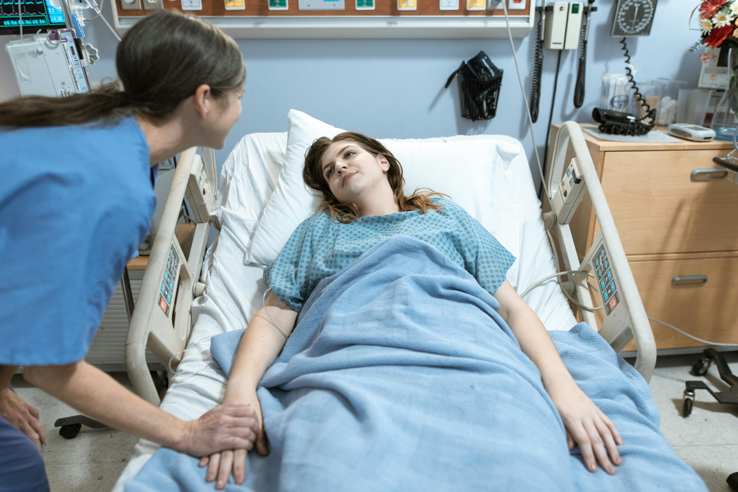 An expat lying in a hospital bed looking at their phone, searching for help
